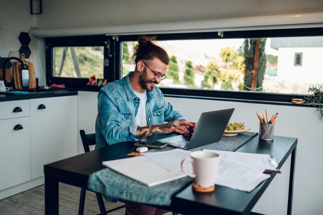 Young business man working at home with laptop and papers on desk.jpg